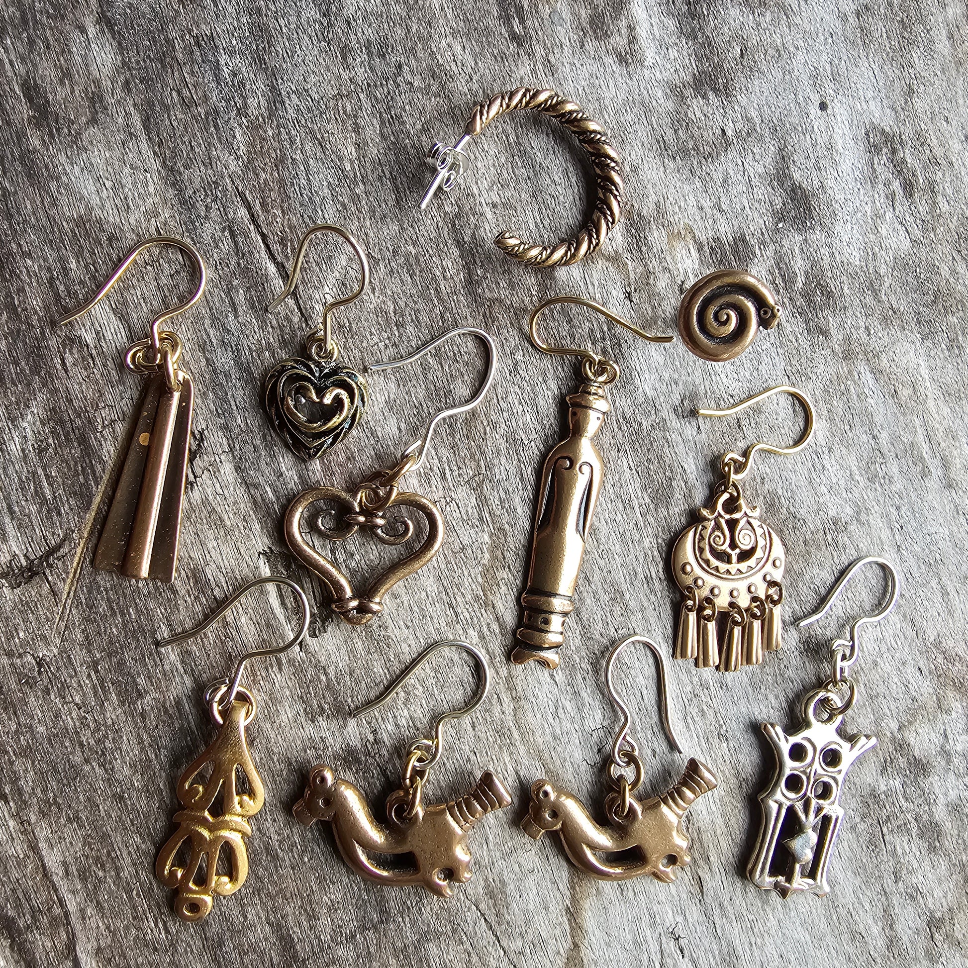 Collection of various silver and gold-toned metal jewelry pieces and charms.