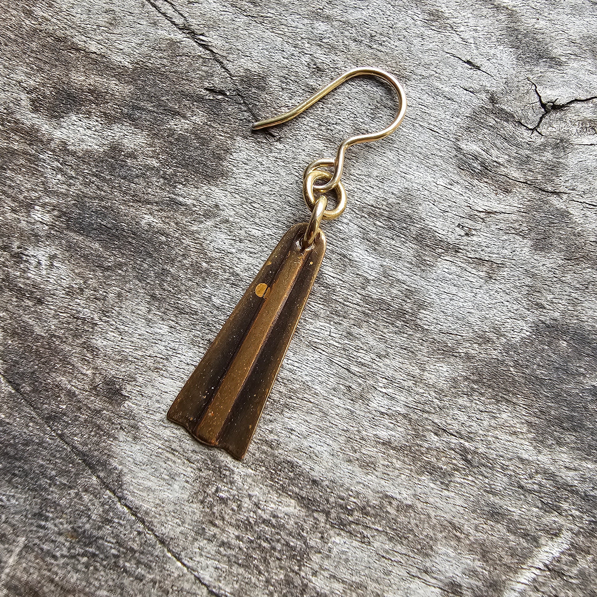 Brass or gold-toned earring with two thin, elongated triangular pendants.