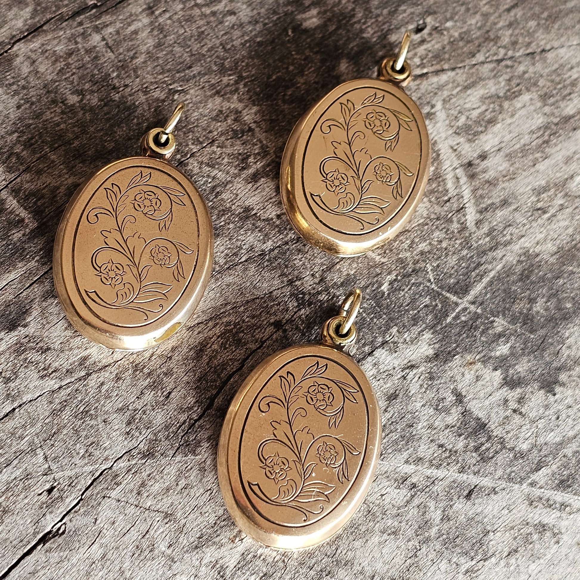 Gold oval lockets with engraved floral designs.