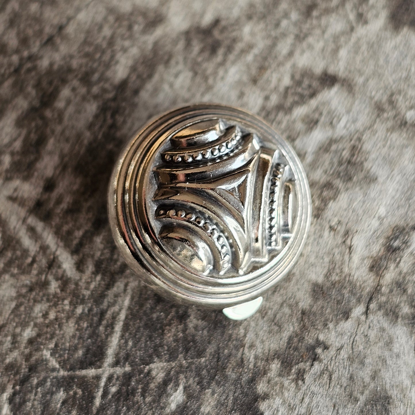 Ornate silver-toned drawer knob or cabinet pull with an intricate geometric design.