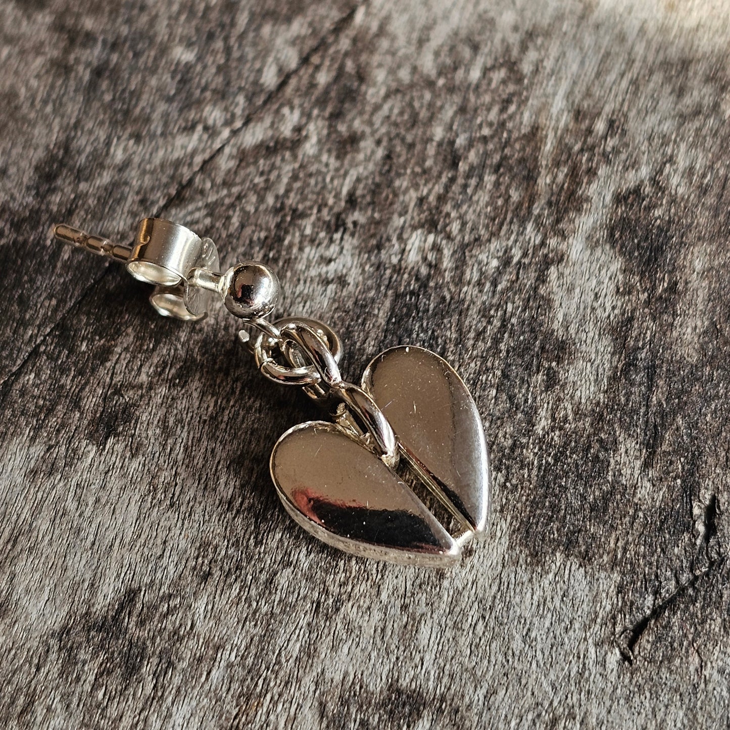 Silver heart-shaped charm or pendant with a small loop at the top.