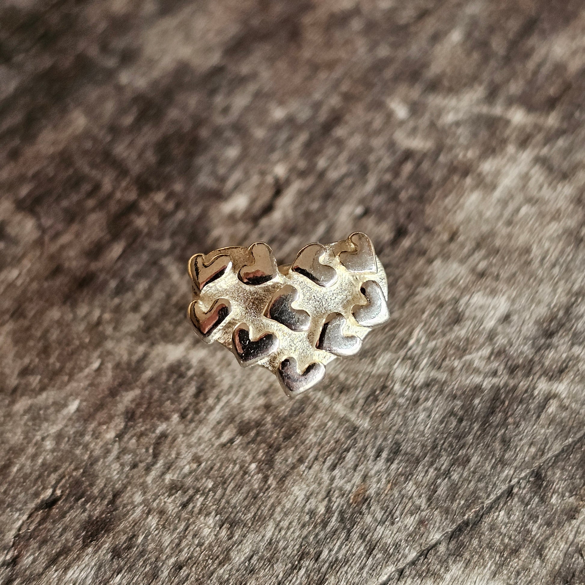 Heart-shaped puzzle piece charm or pendant made of metal.