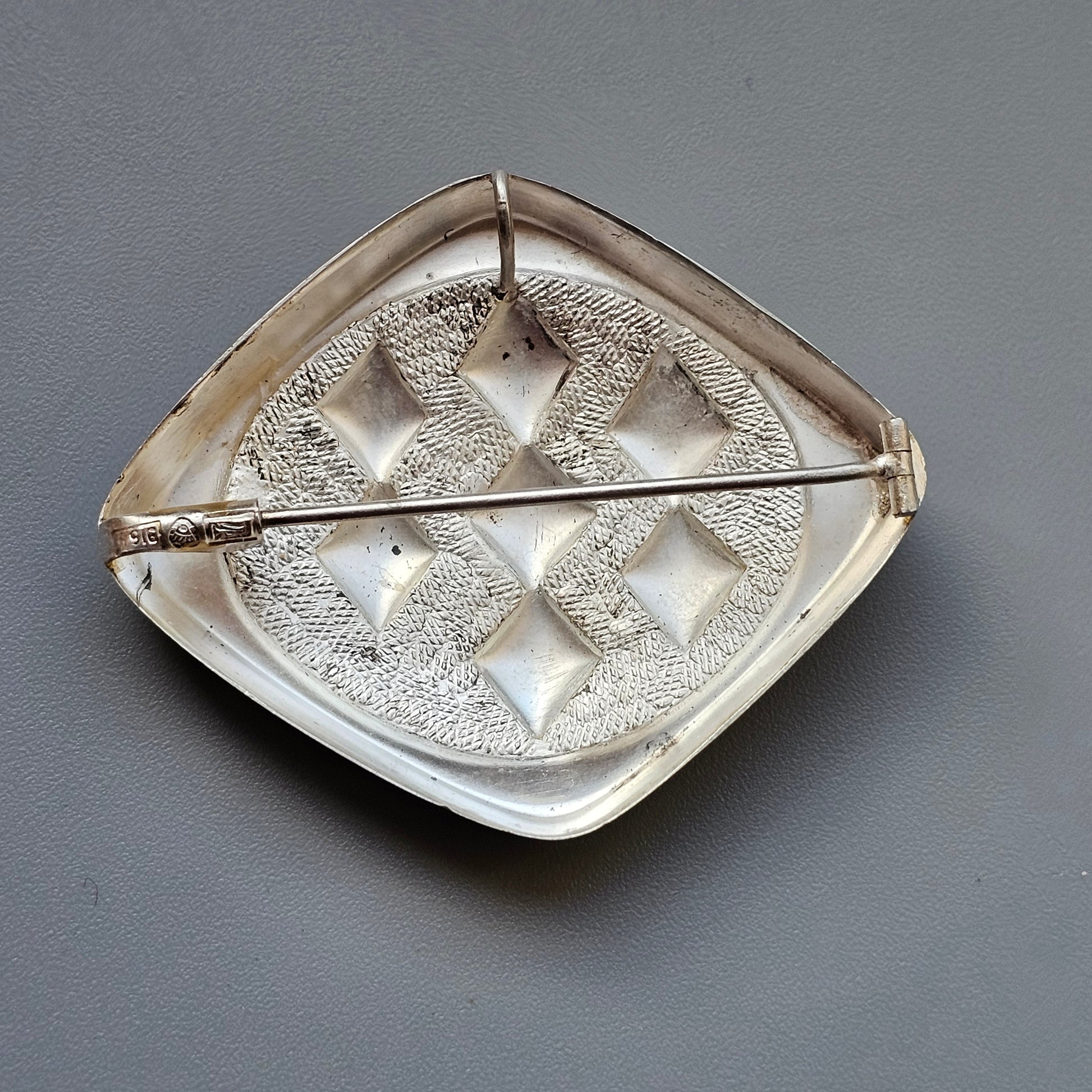 Decorative ceramic dish with an intricate leaf-shaped design and textured pattern.