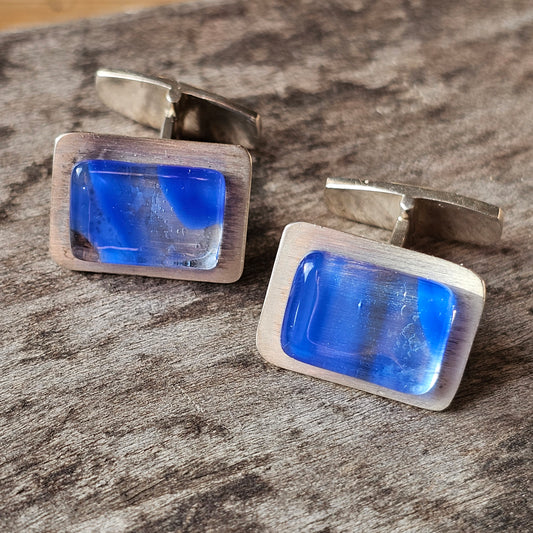 Pair of silver cufflinks with rectangular blue glass or gemstone inlays.