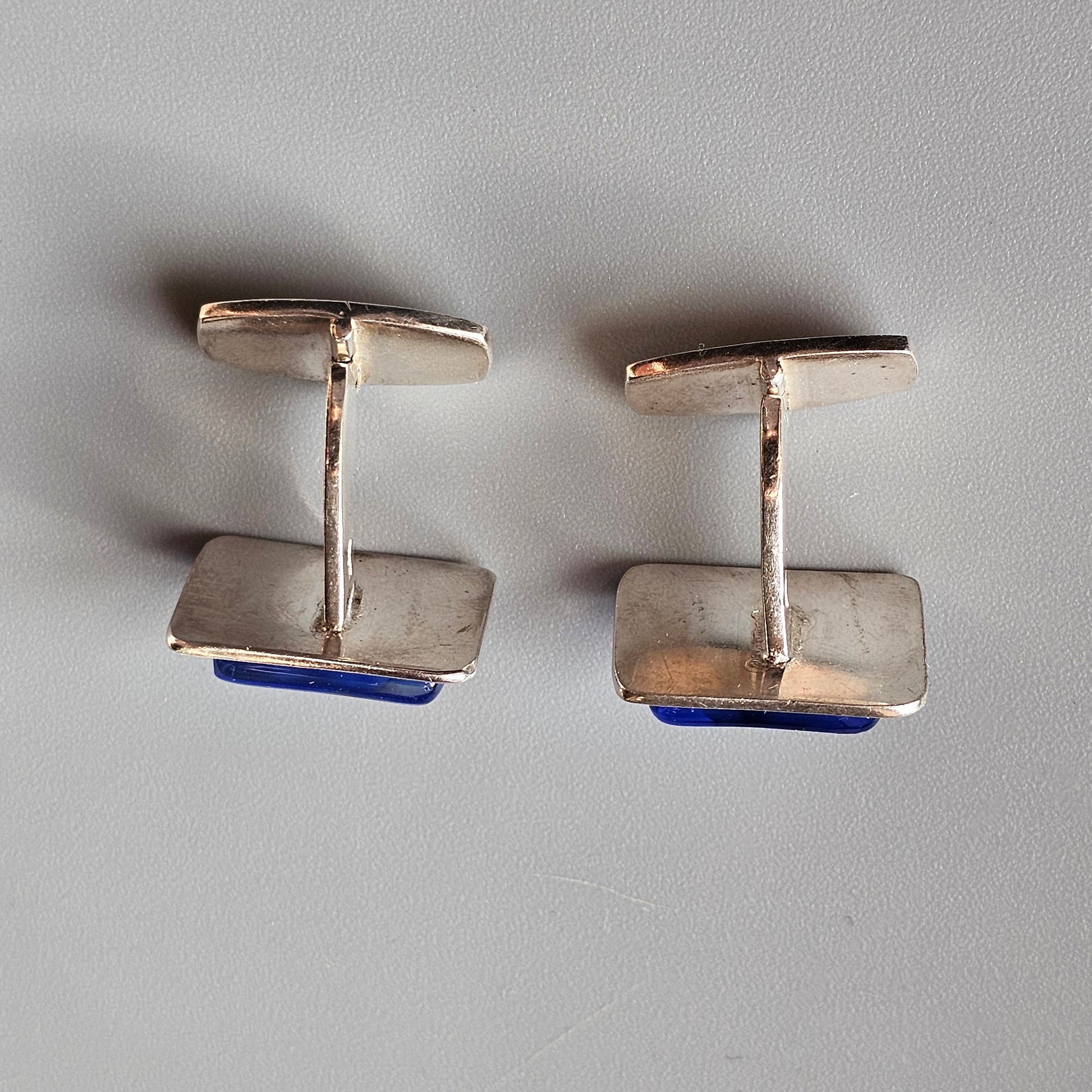 Pair of silver-toned cufflinks with blue enamel accents.