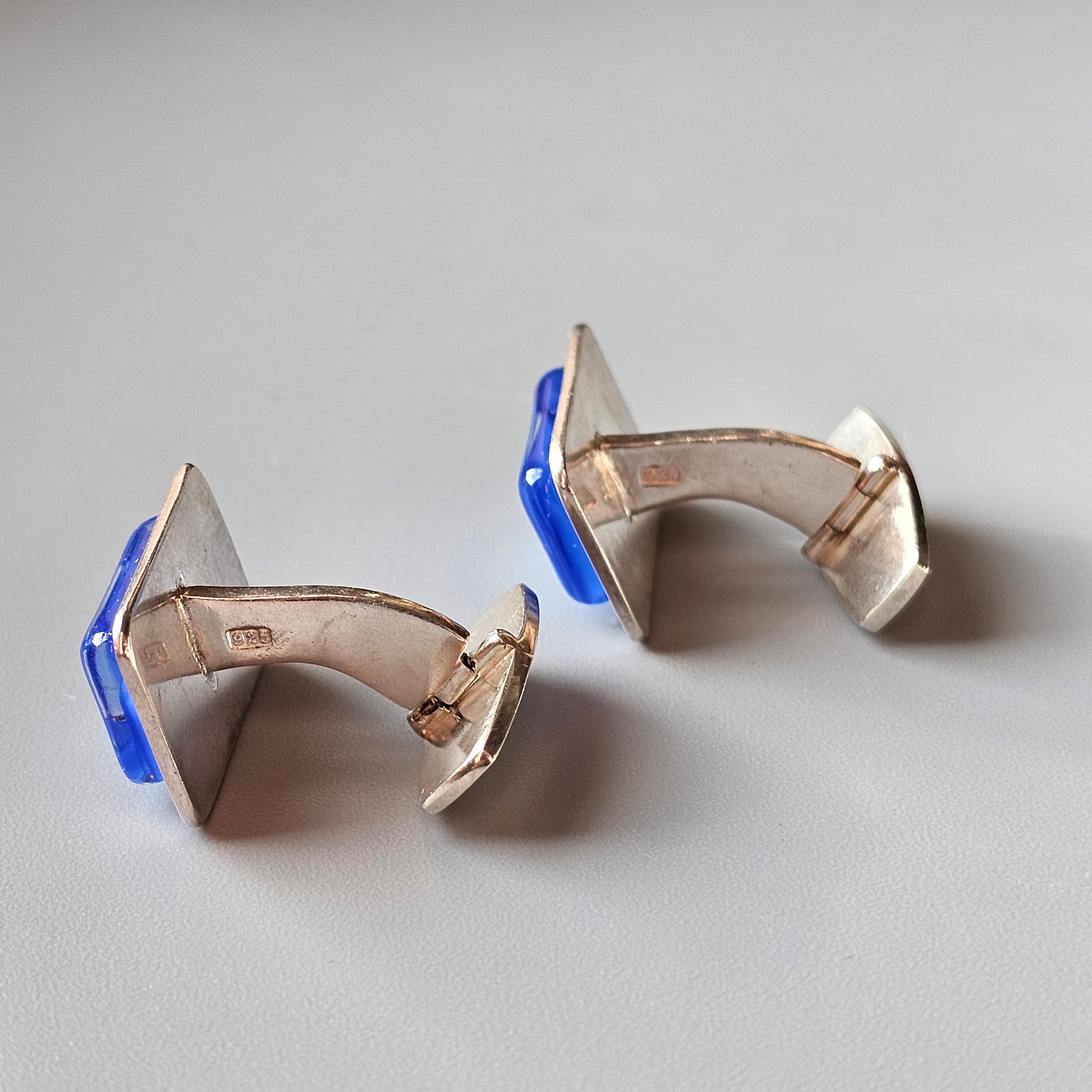 Pair of modernist cufflinks with blue enamel accents and triangular shapes.