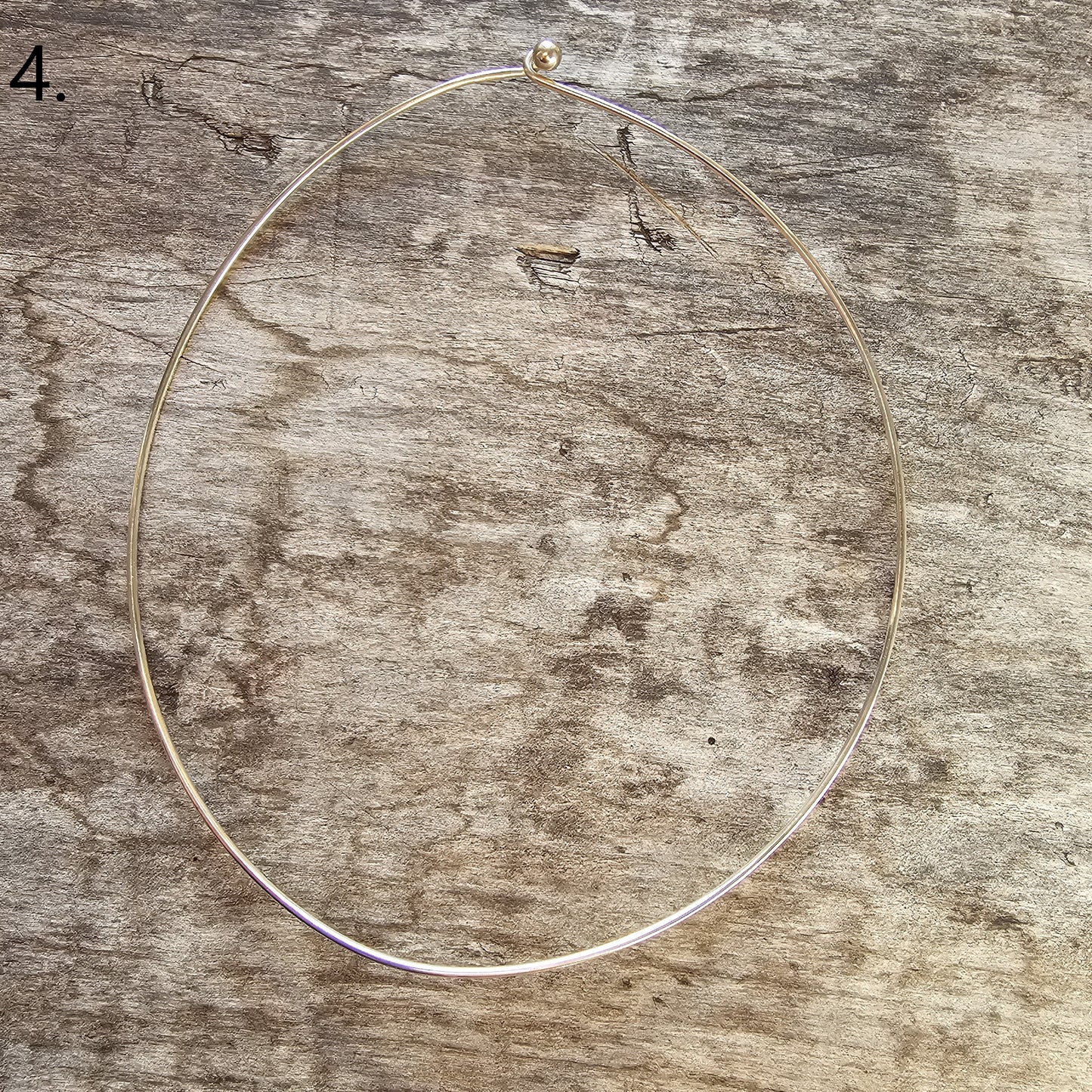 Thin, circular metal wire or necklace.