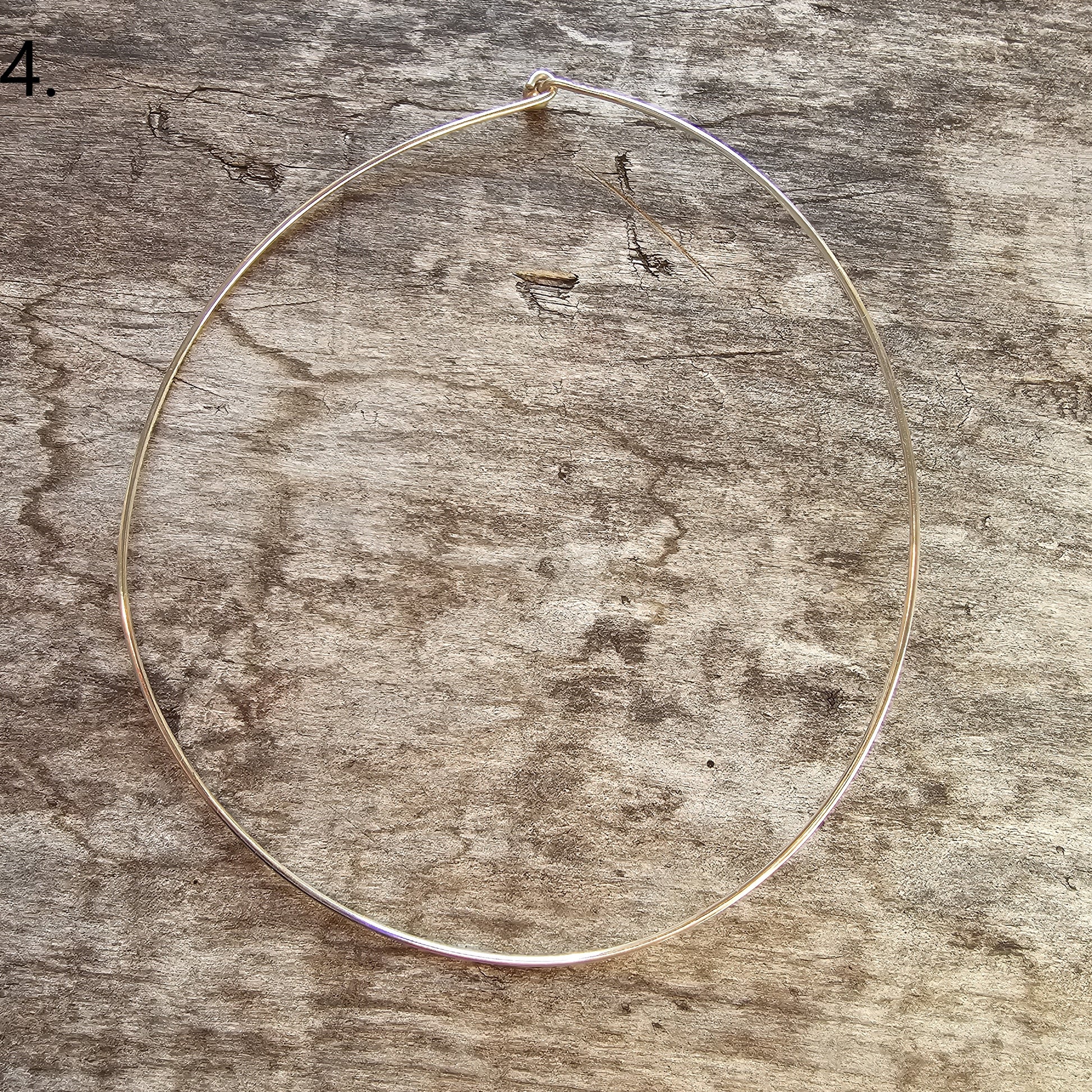 Thin circular metal wire or hoop on a textured surface.