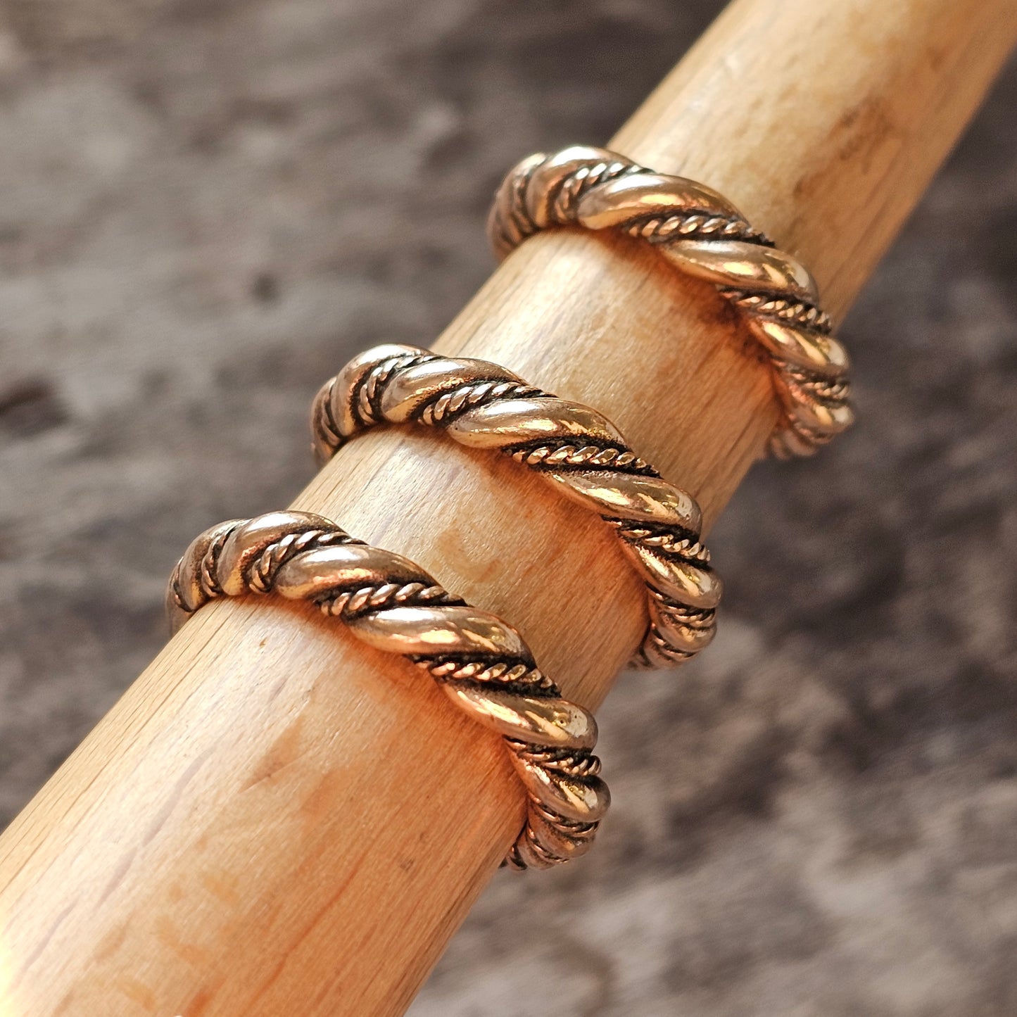 Twisted gold and silver metal ring with a rope-like design.