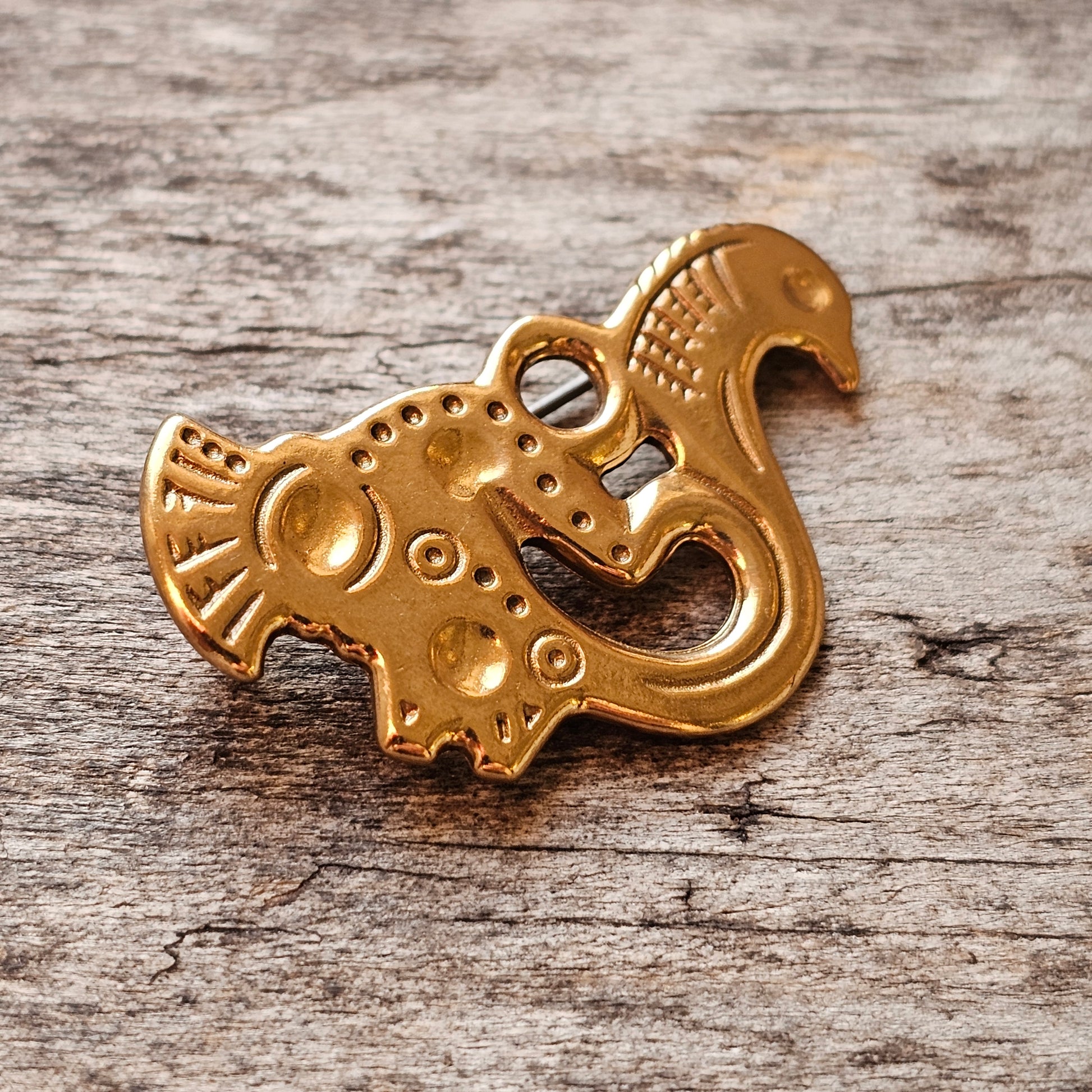 Golden ornamental pendant shaped like a stylized animal or mythical creature.