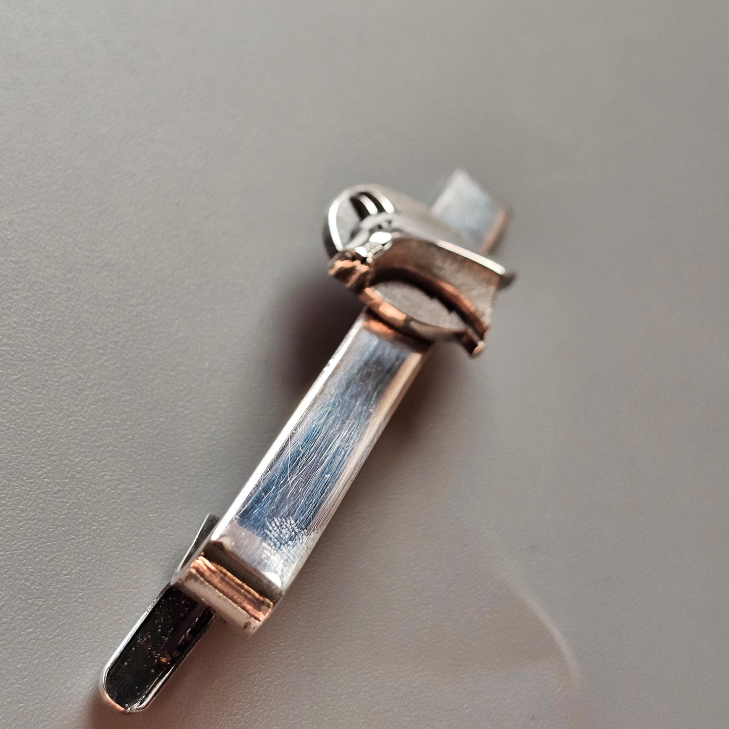 Silver and copper-toned mezuzah pendant.