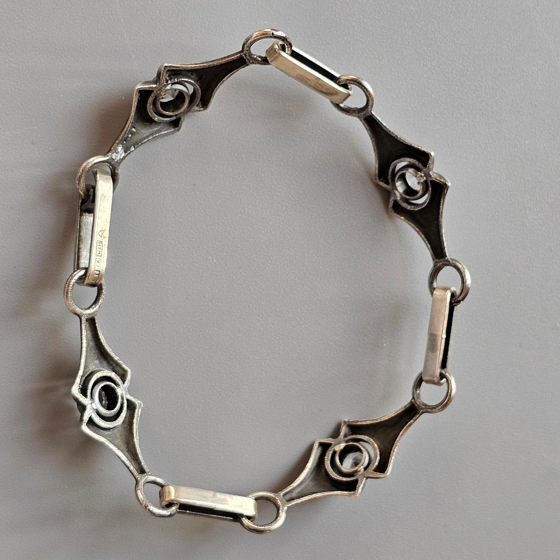 Silver bracelet with geometric links connected by small bars.