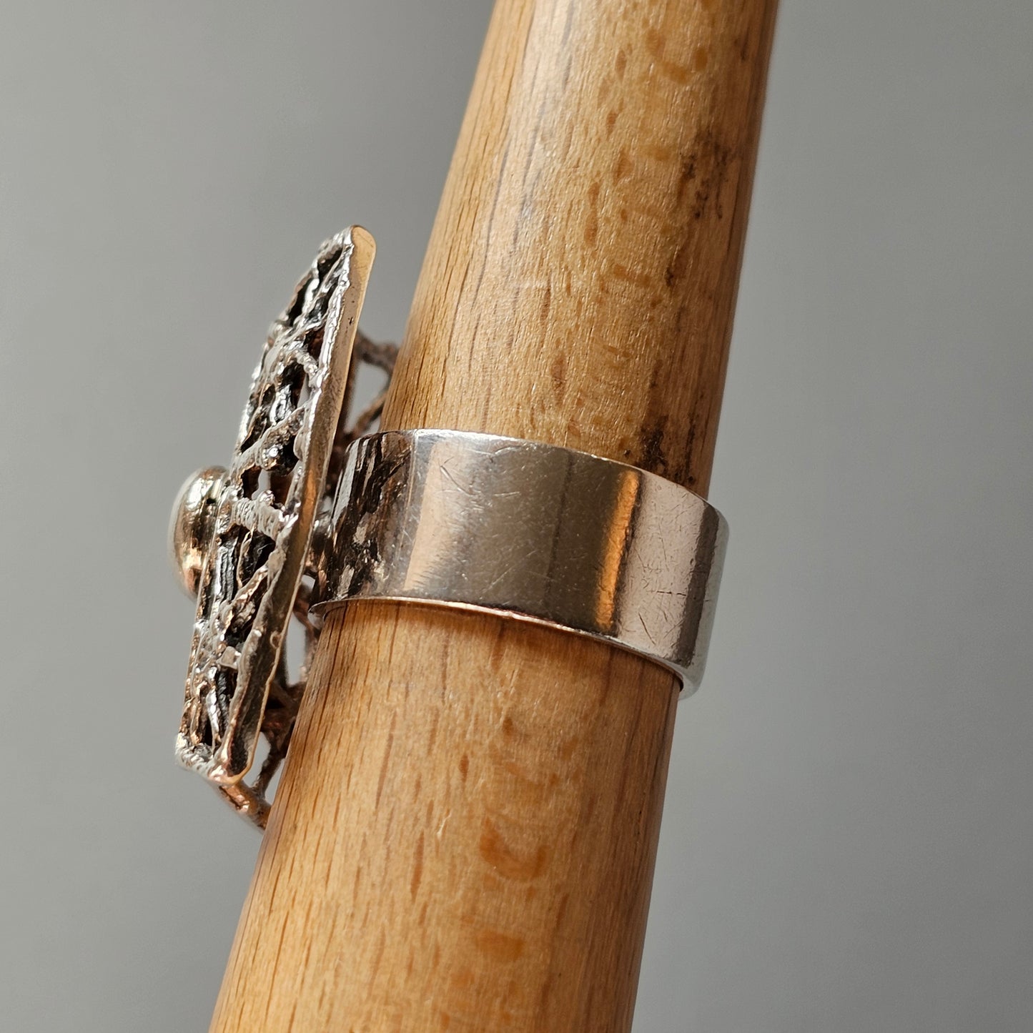 Ornate silver ring with an intricate butterfly-shaped design on top.