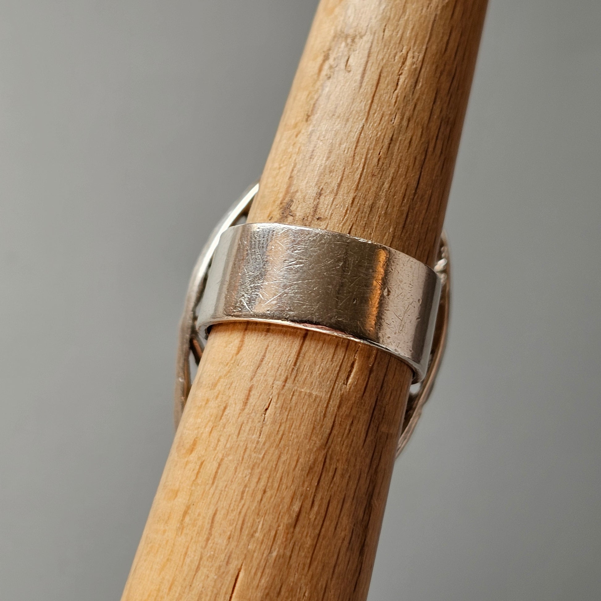 Silver ring on a wooden surface.