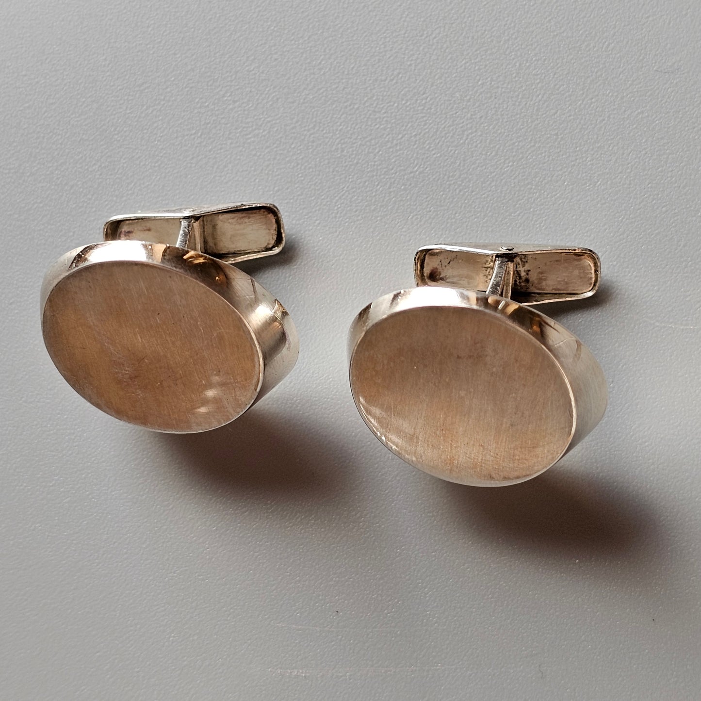 Pair of oval gold-colored metal cufflinks.