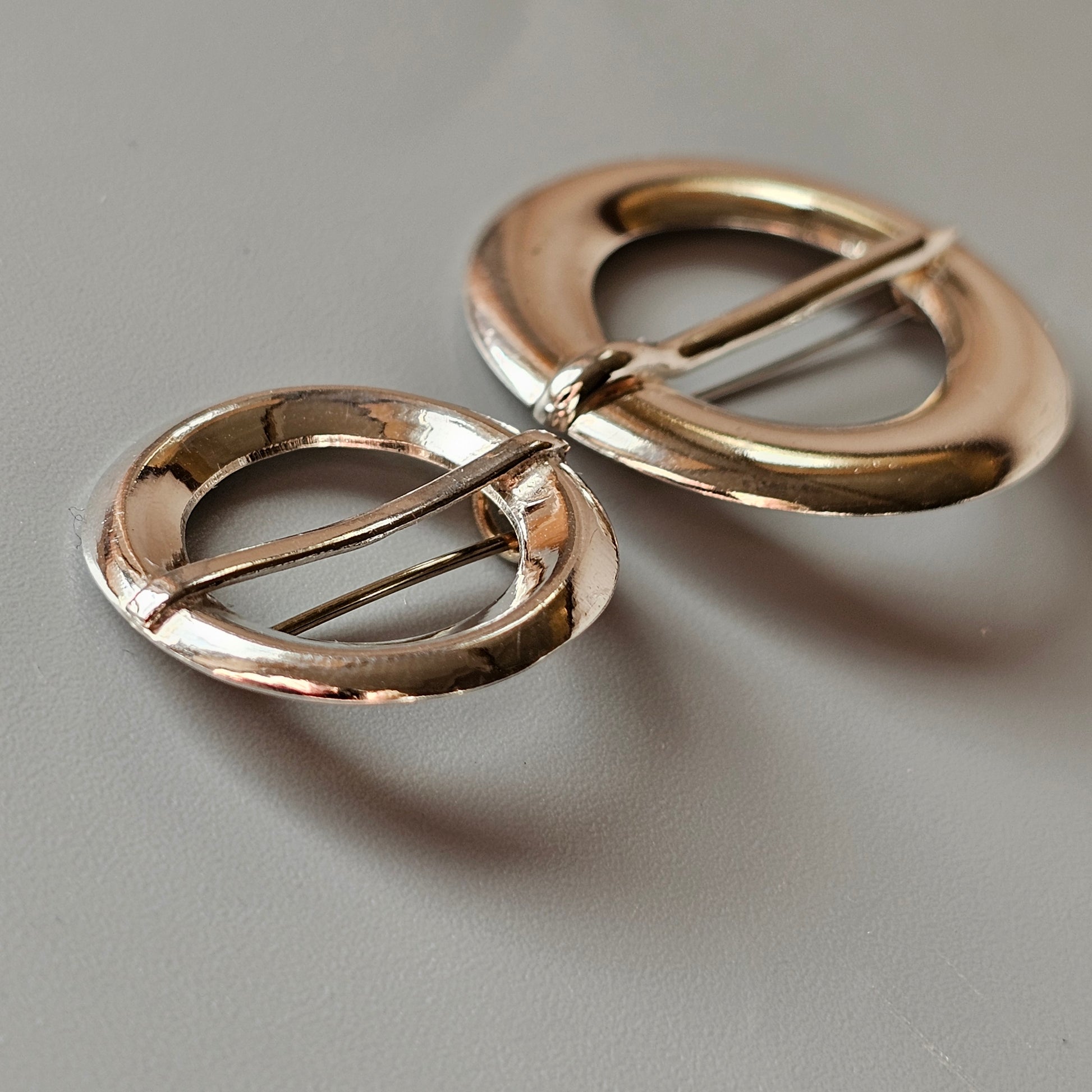 Pair of gold-colored metal scissors with circular handles.