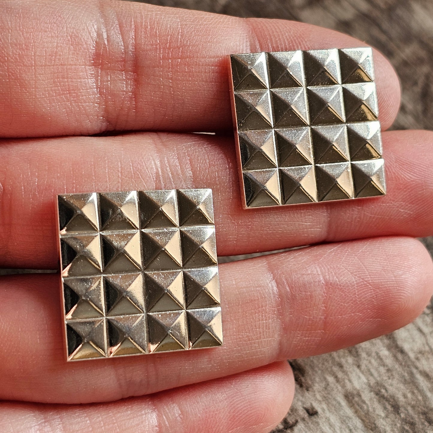 Square metal studs with a pyramid pattern.