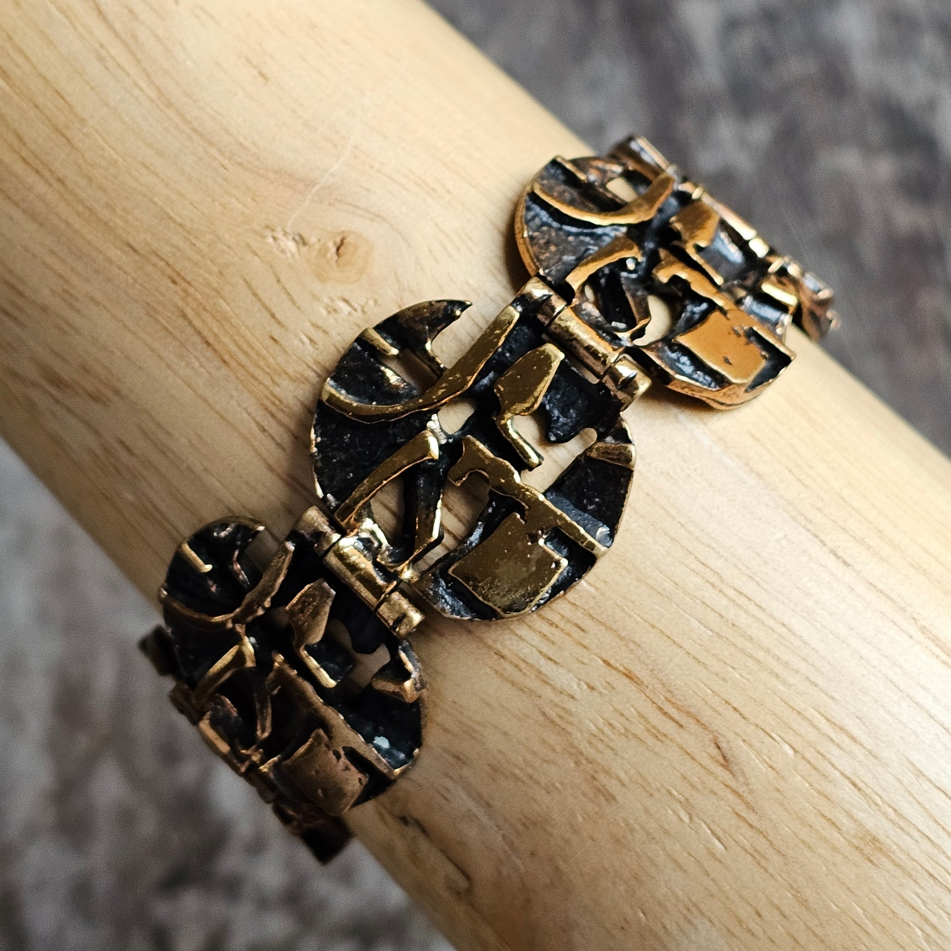 Ornate gold-toned metal bracelet with intricate geometric patterns.