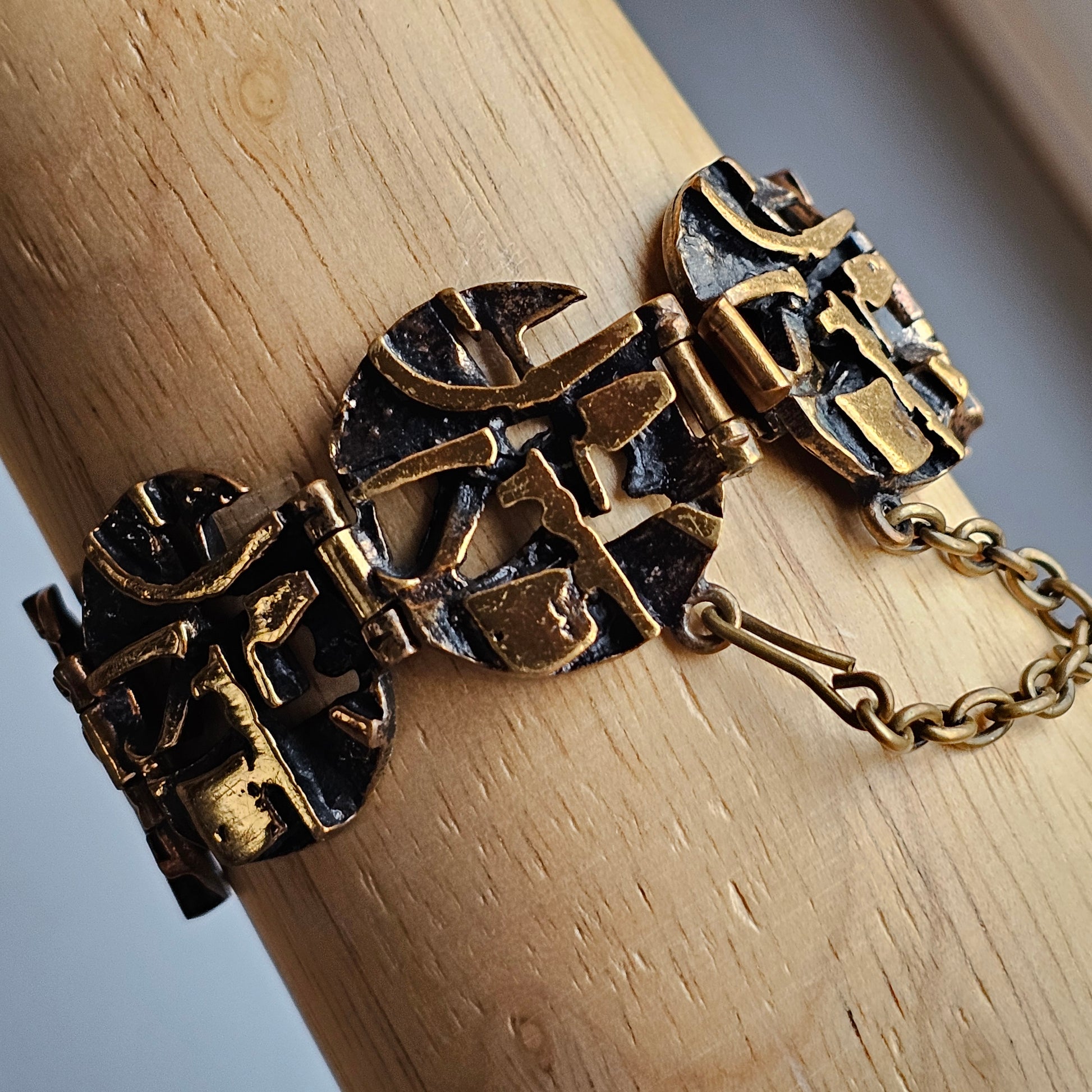 Ornate bronze bracelet with intricate geometric designs and a chain clasp.