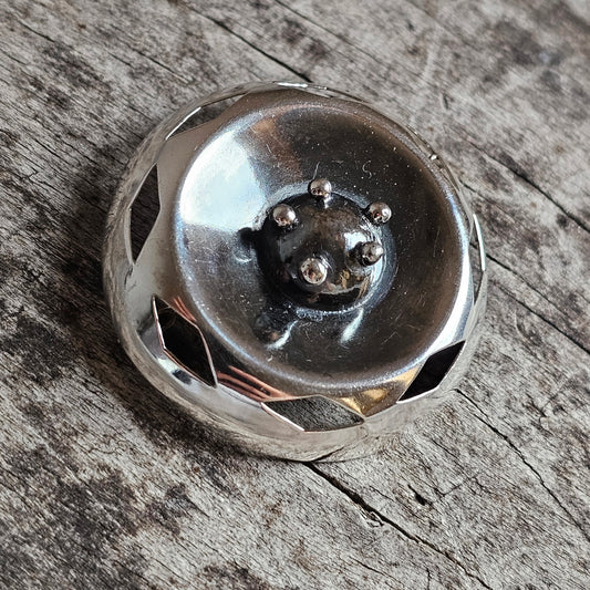 Metallic button or fastener with a decorative bear face design.