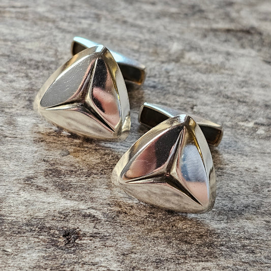 Pair of silver triangular cufflinks with a polished, geometric design.