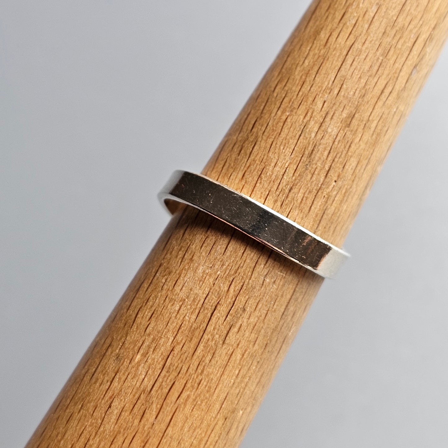 Silver ring wrapped around a wooden dowel or rod.