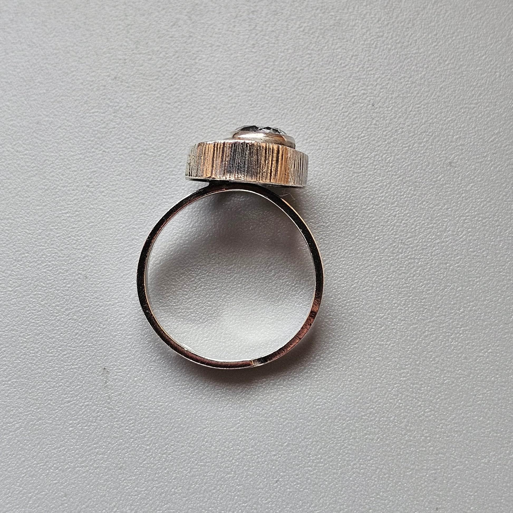 Silver ring with a textured, domed top.