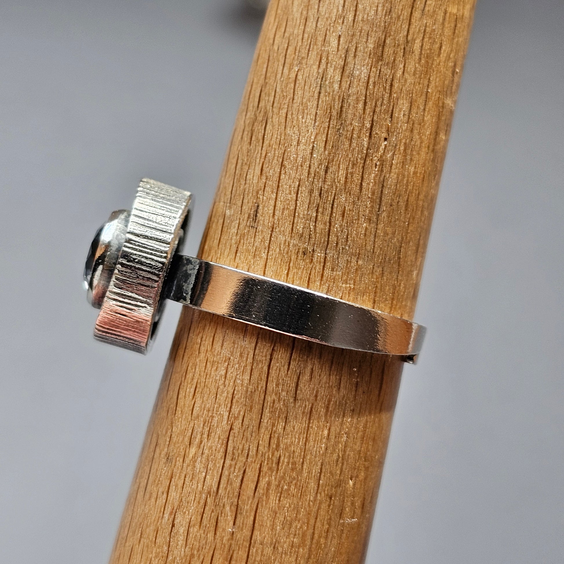 Metal ring or band wrapped around a wooden dowel or rod.