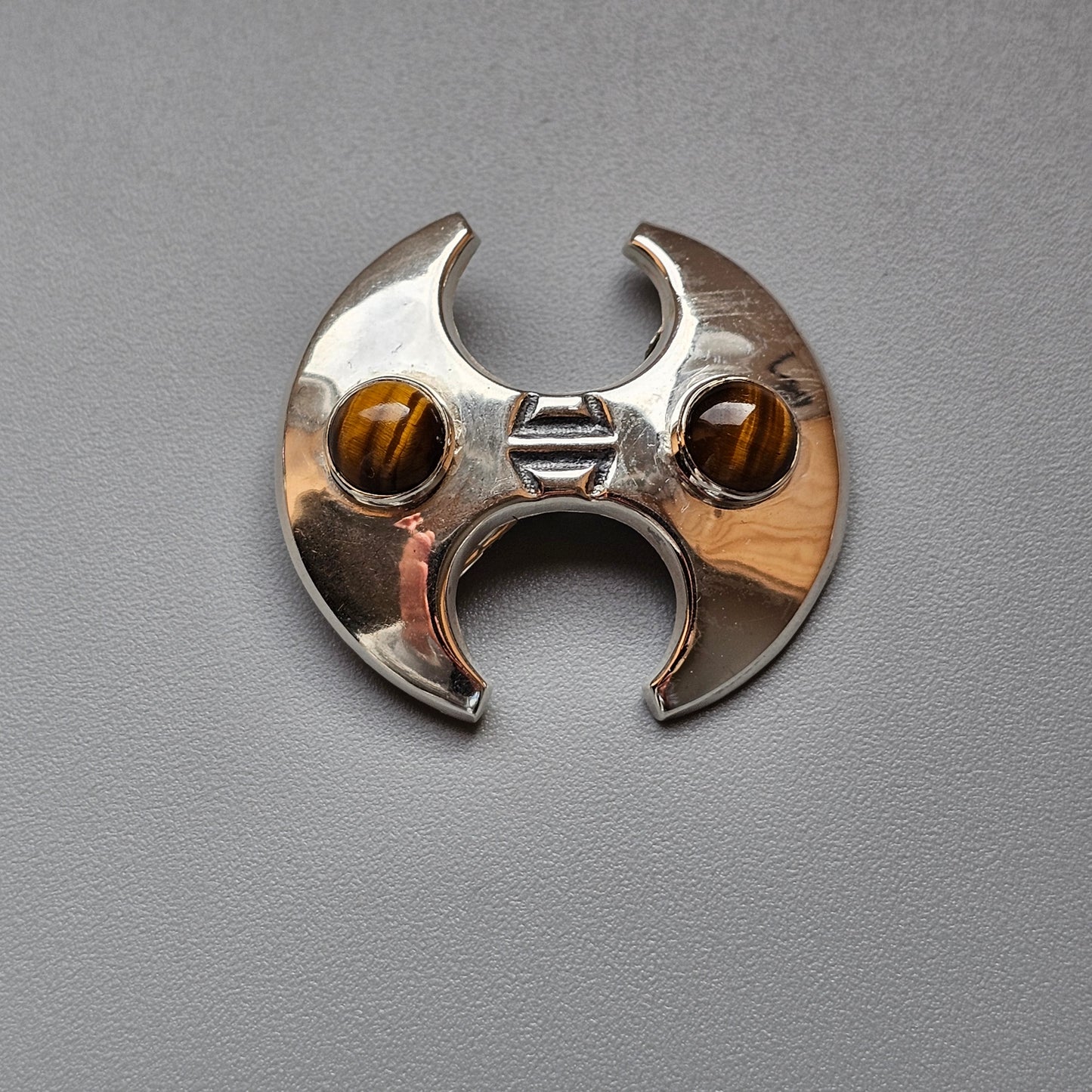 Metallic bat-shaped ring with amber-colored gemstone eyes.