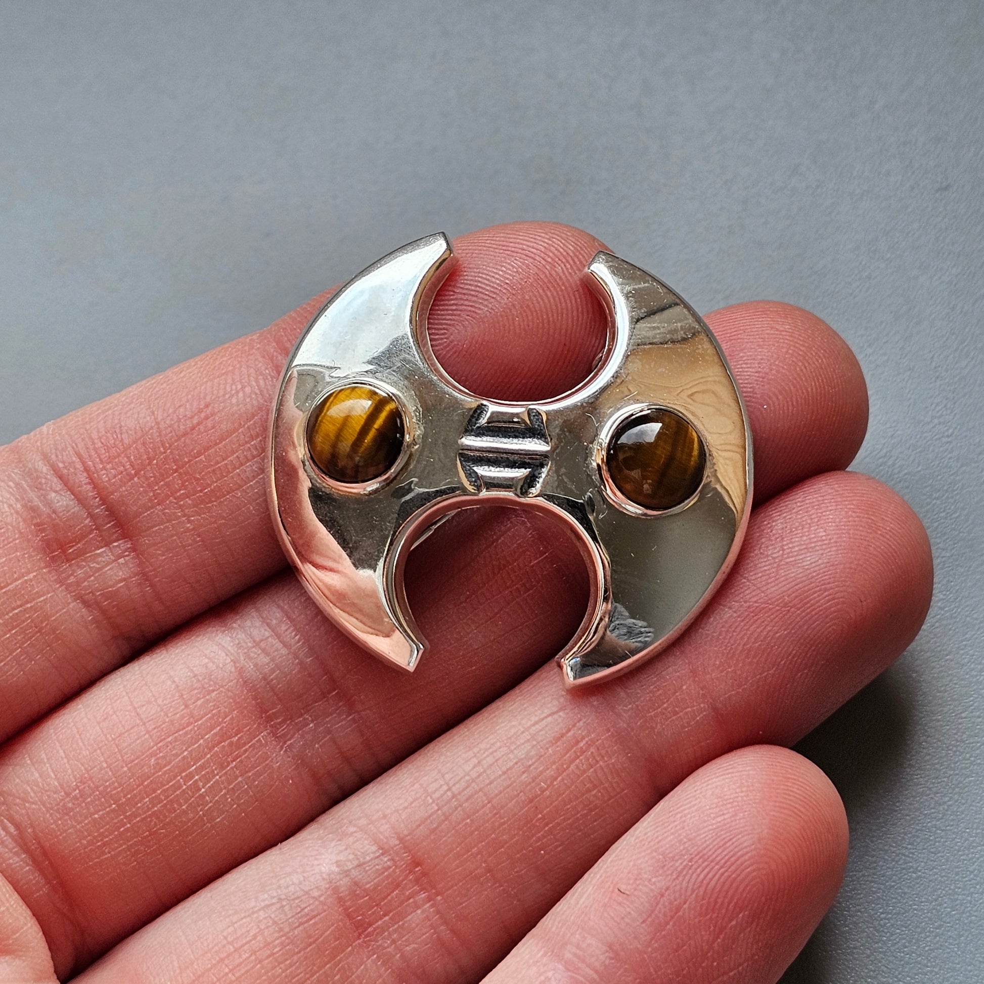 Metallic fidget spinner with two tiger’s eye gemstones inset.