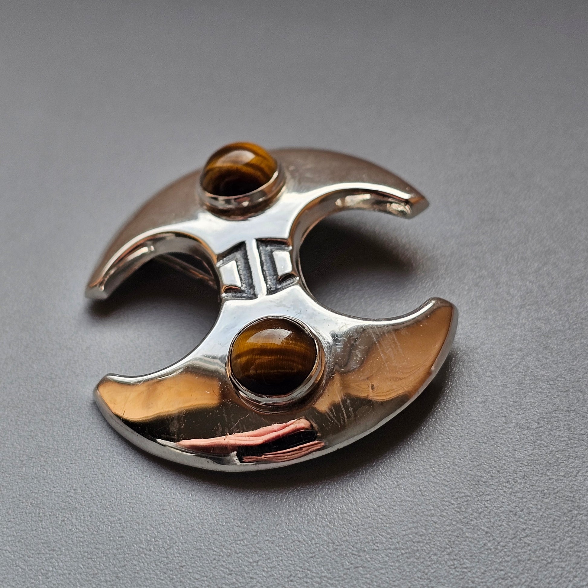 Metallic fidget spinner with two amber-colored glass or gemstone inlays.