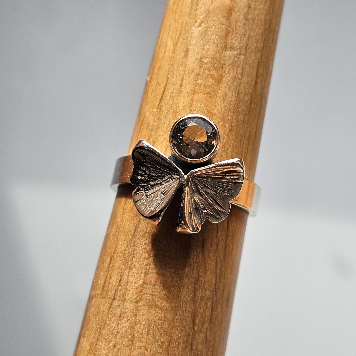 Silver ring featuring a butterfly design with a small gemstone.