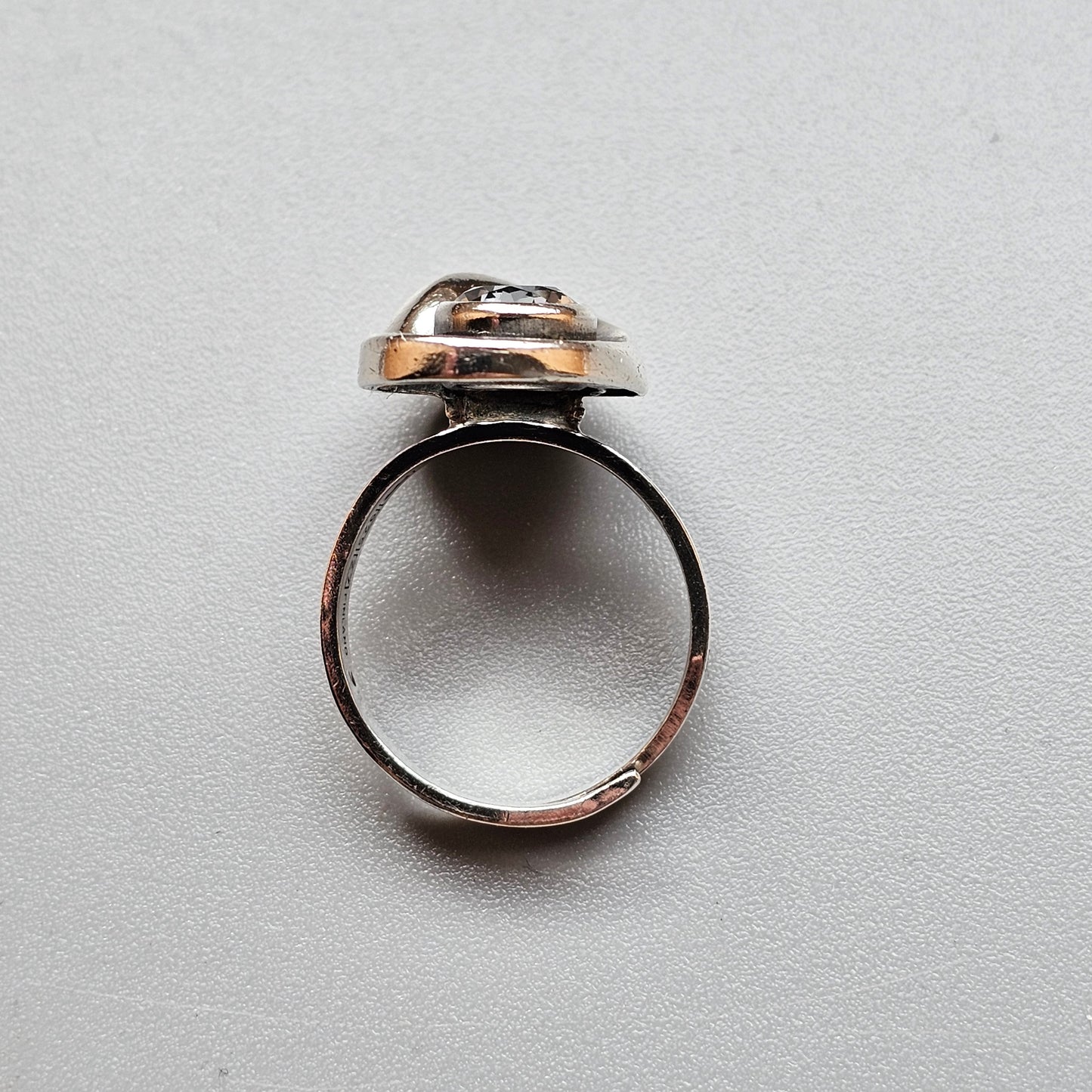 Ring with a metallic button-like top featuring mixed silver and gold tones.