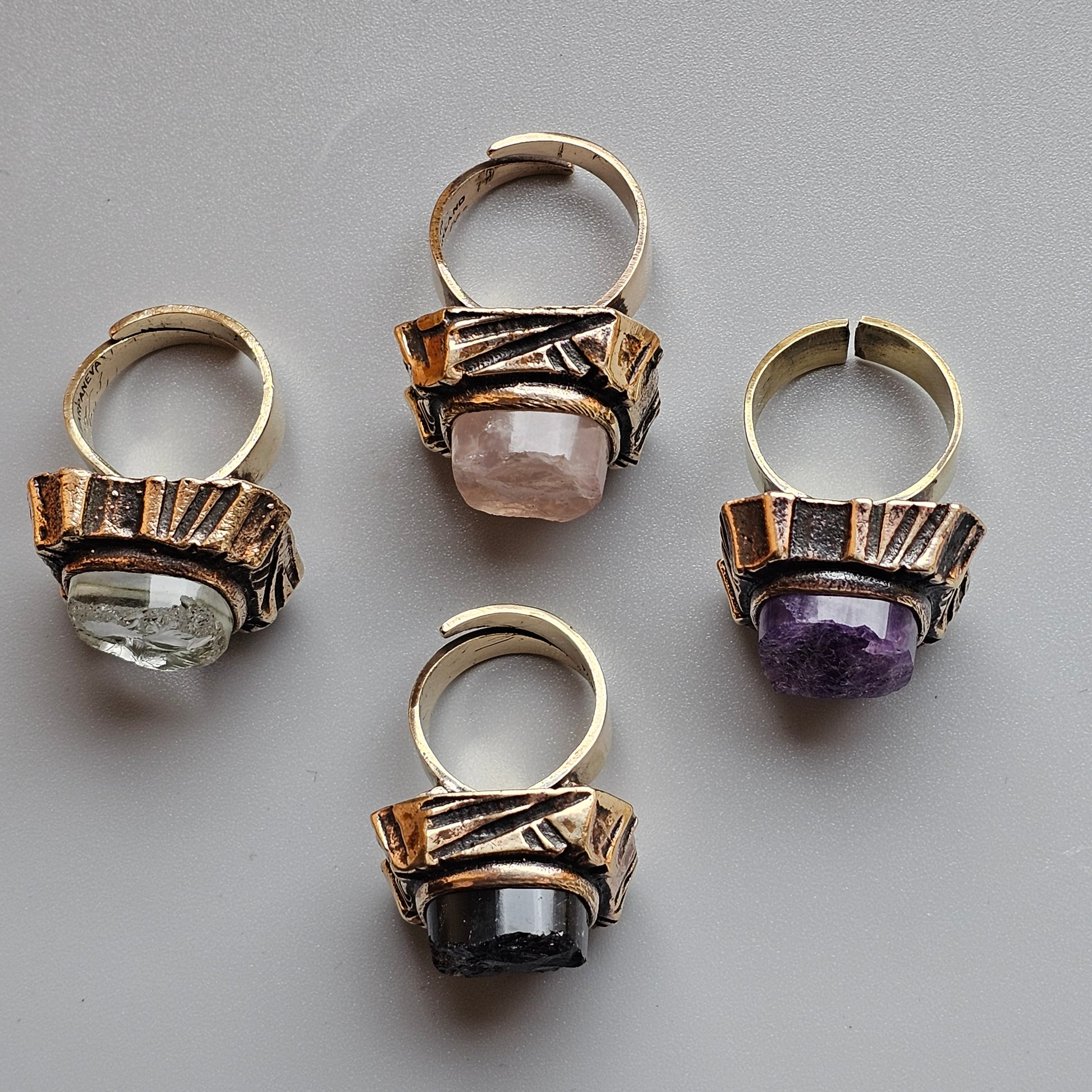 Four ornate rings with gemstones set in decorative metalwork.