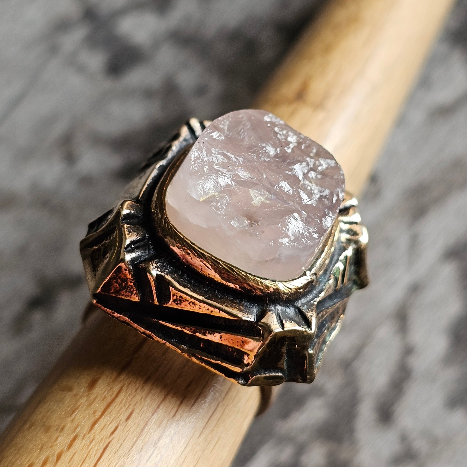 Ornate silver ring featuring a pale pink rough gemstone in an intricate setting.