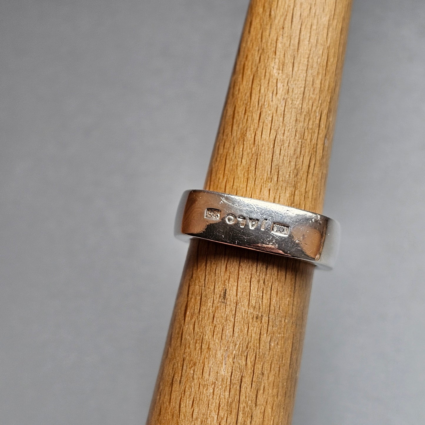 Silver ring with hallmarks or stamps visible on its surface.