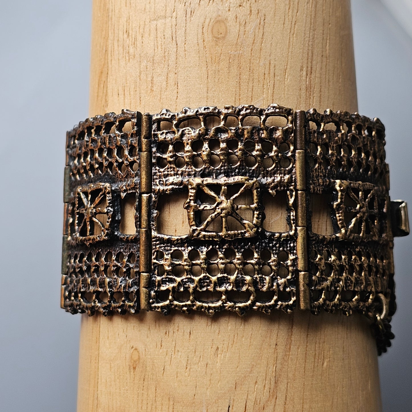 Ornate metal bracelet with intricate filigree patterns and geometric designs.