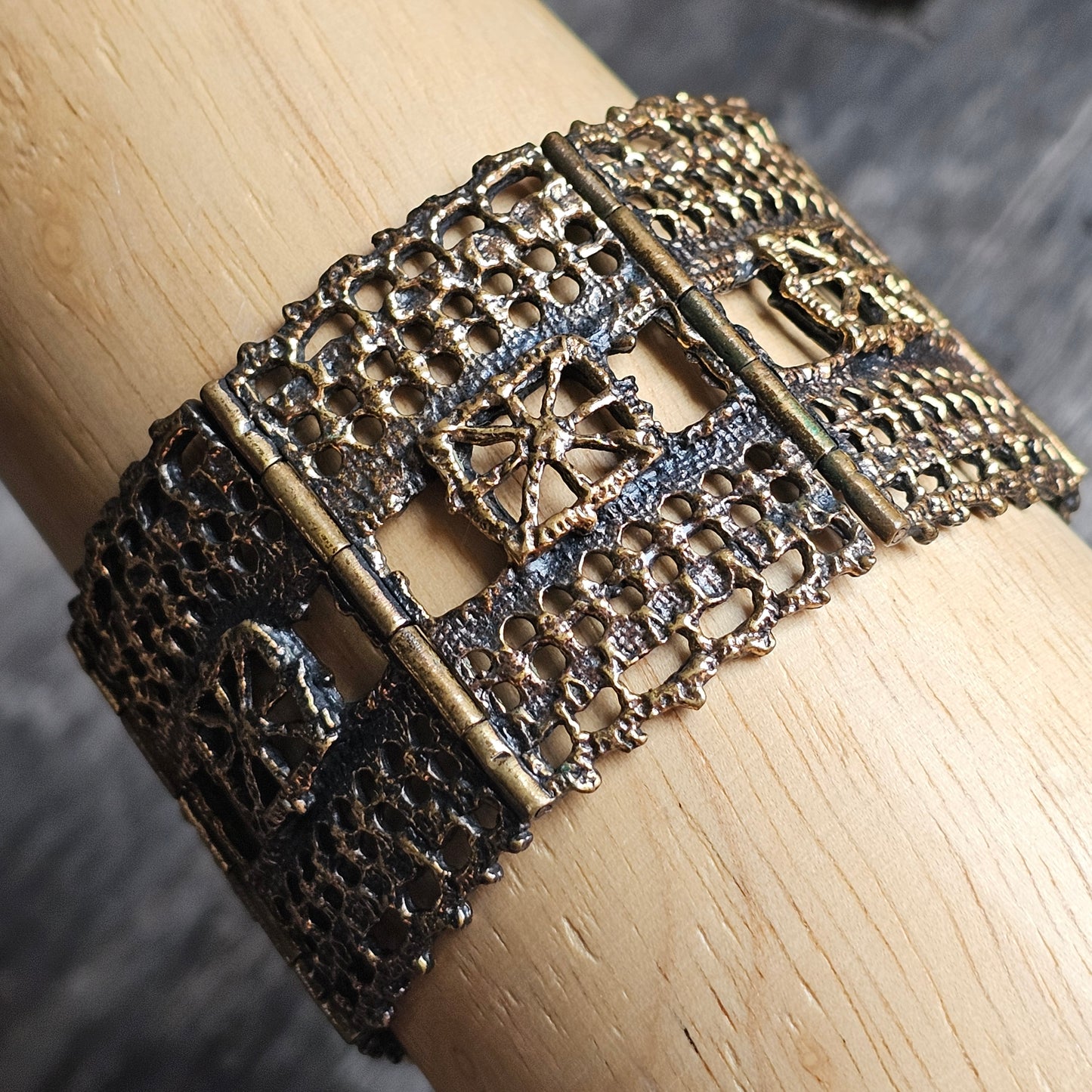 Ornate antique-style metal cuff bracelet with intricate filigree patterns.