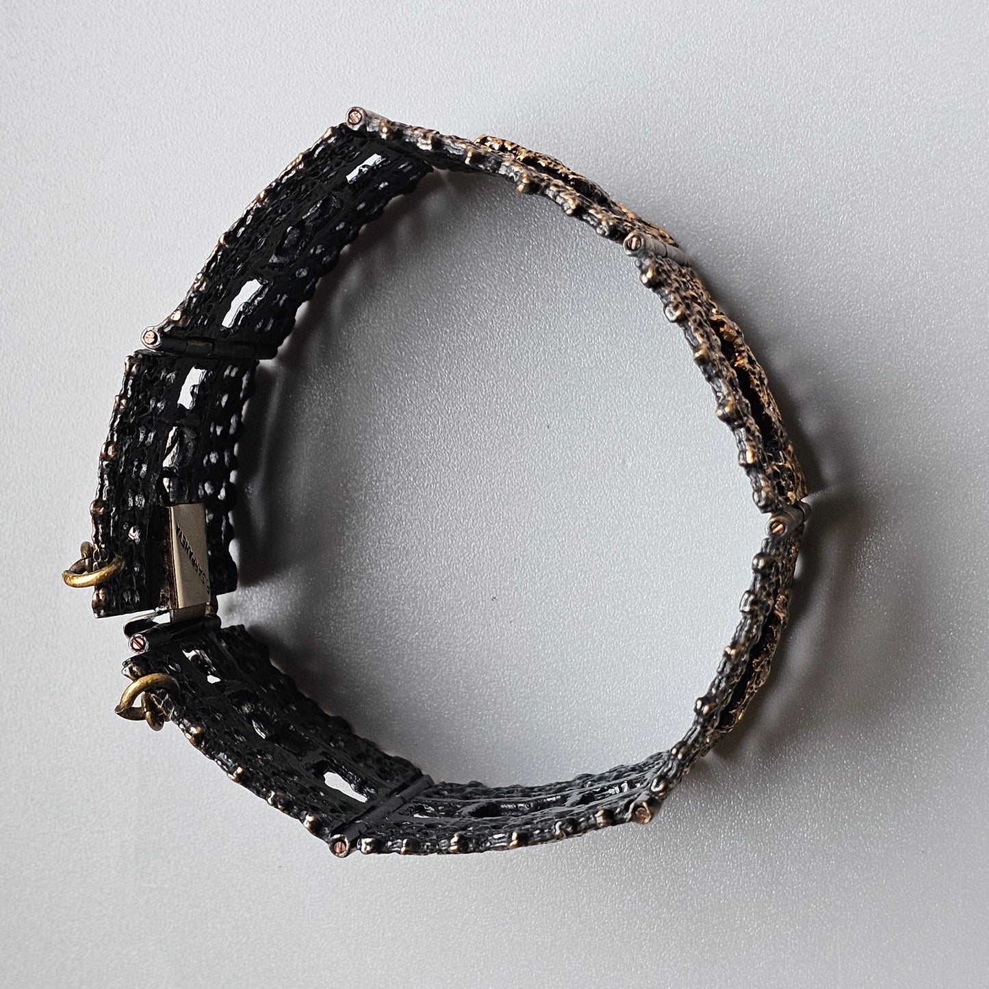 Black beaded bracelet with metallic accents and a clasp.