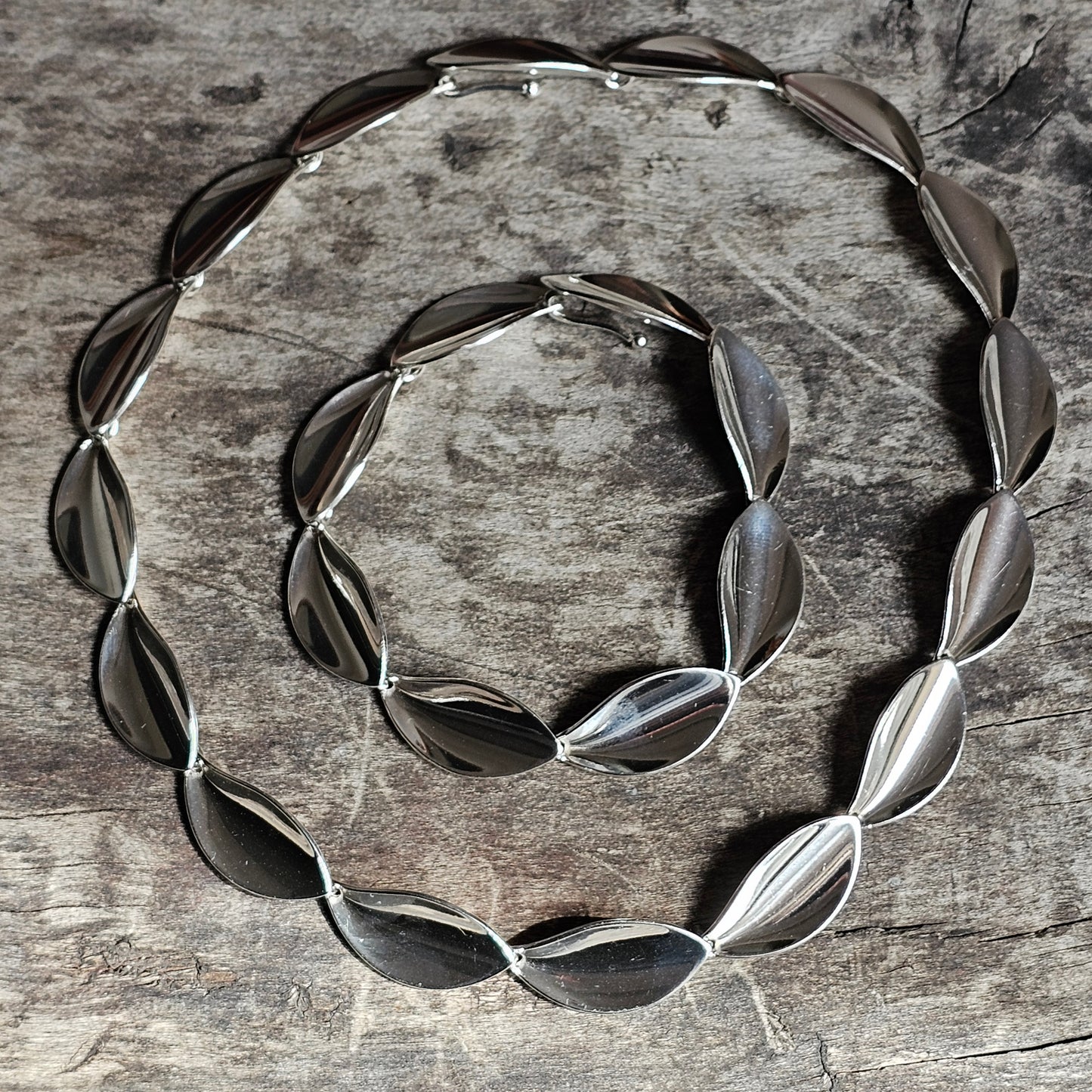 Silver leaf-shaped necklace arranged in a spiral pattern.