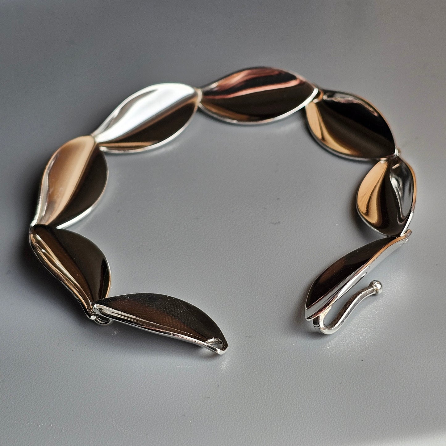 Metallic bracelet with leaf-shaped links in mixed gold, silver, and bronze tones.