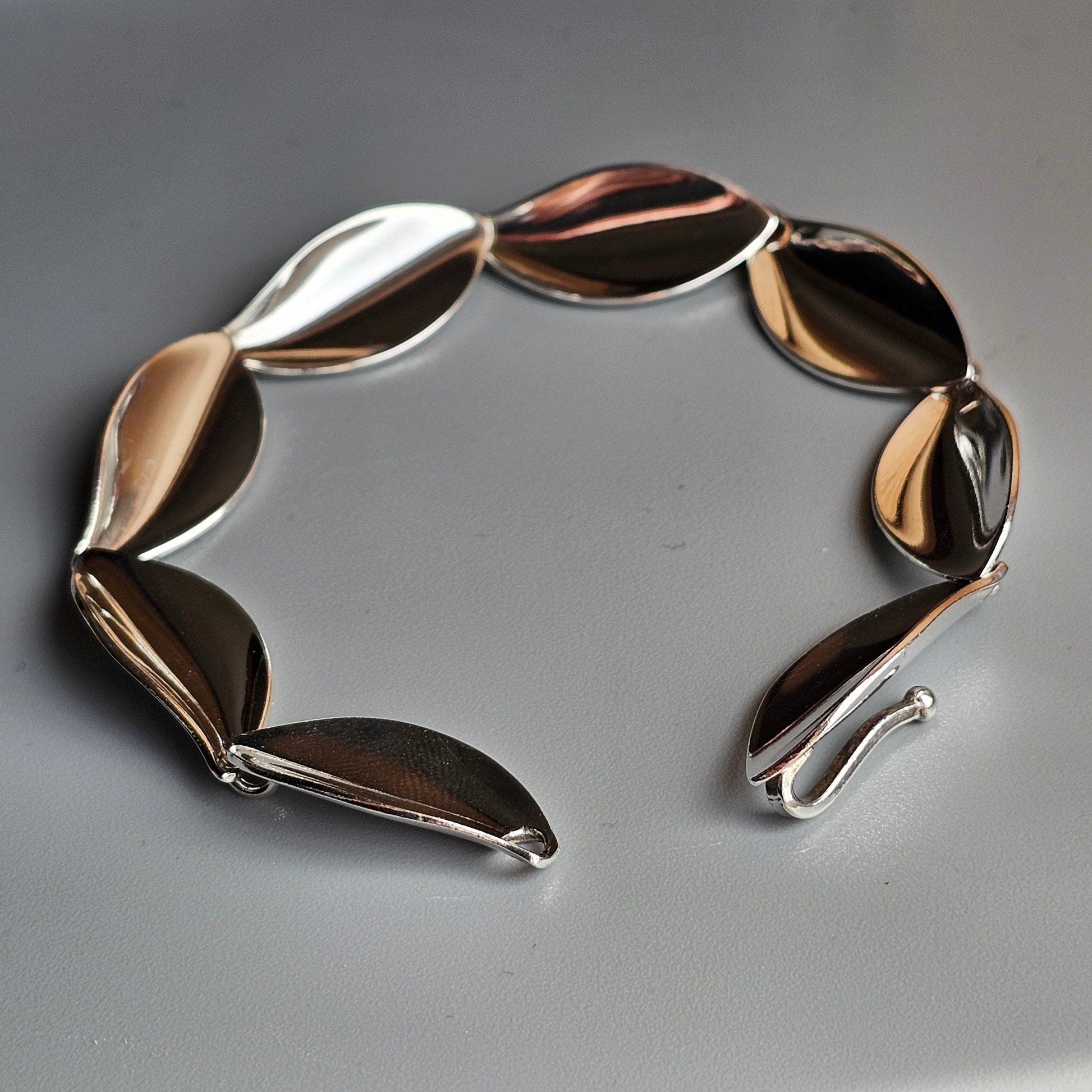 Metallic bracelet with leaf-shaped links in mixed gold, silver, and bronze tones.