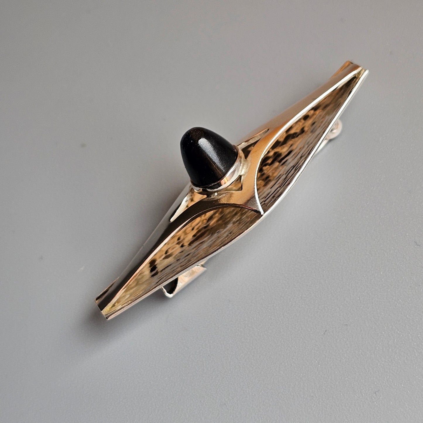 Ornate metal and wood hair clip or barrette with a sleek, elongated design.