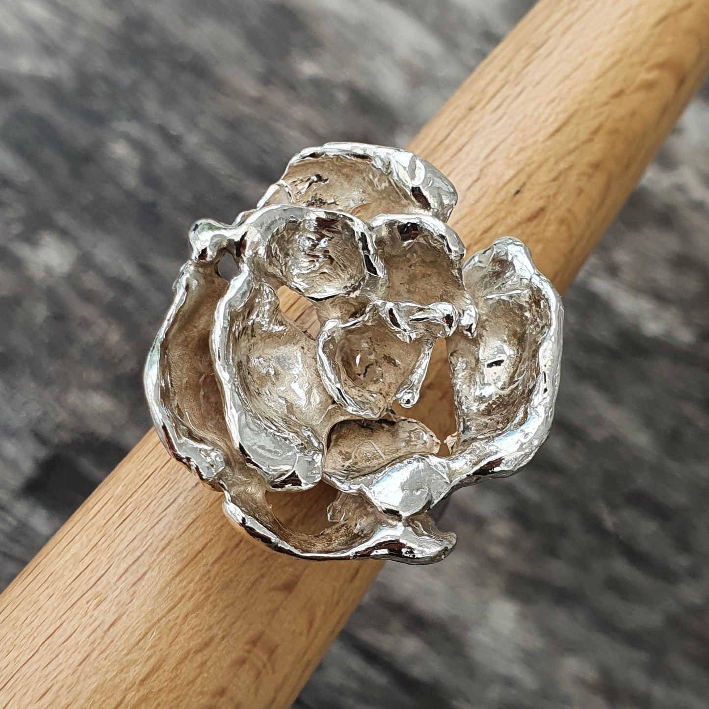 Silver ring shaped like a blooming flower or rose.