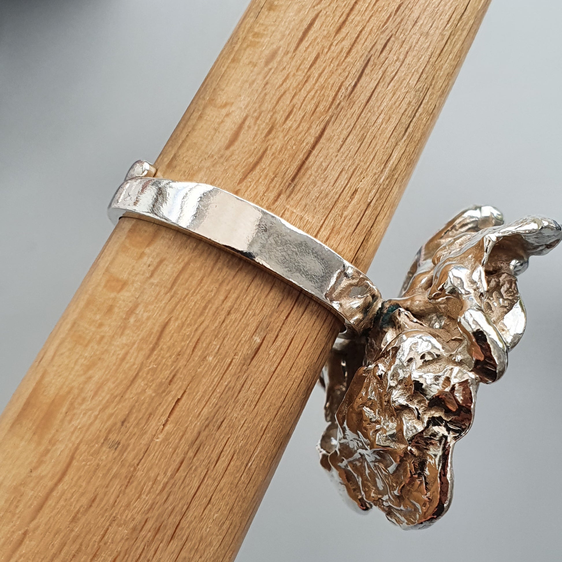 Silver ring with an abstract sculptural element resembling a crumpled or organic form.