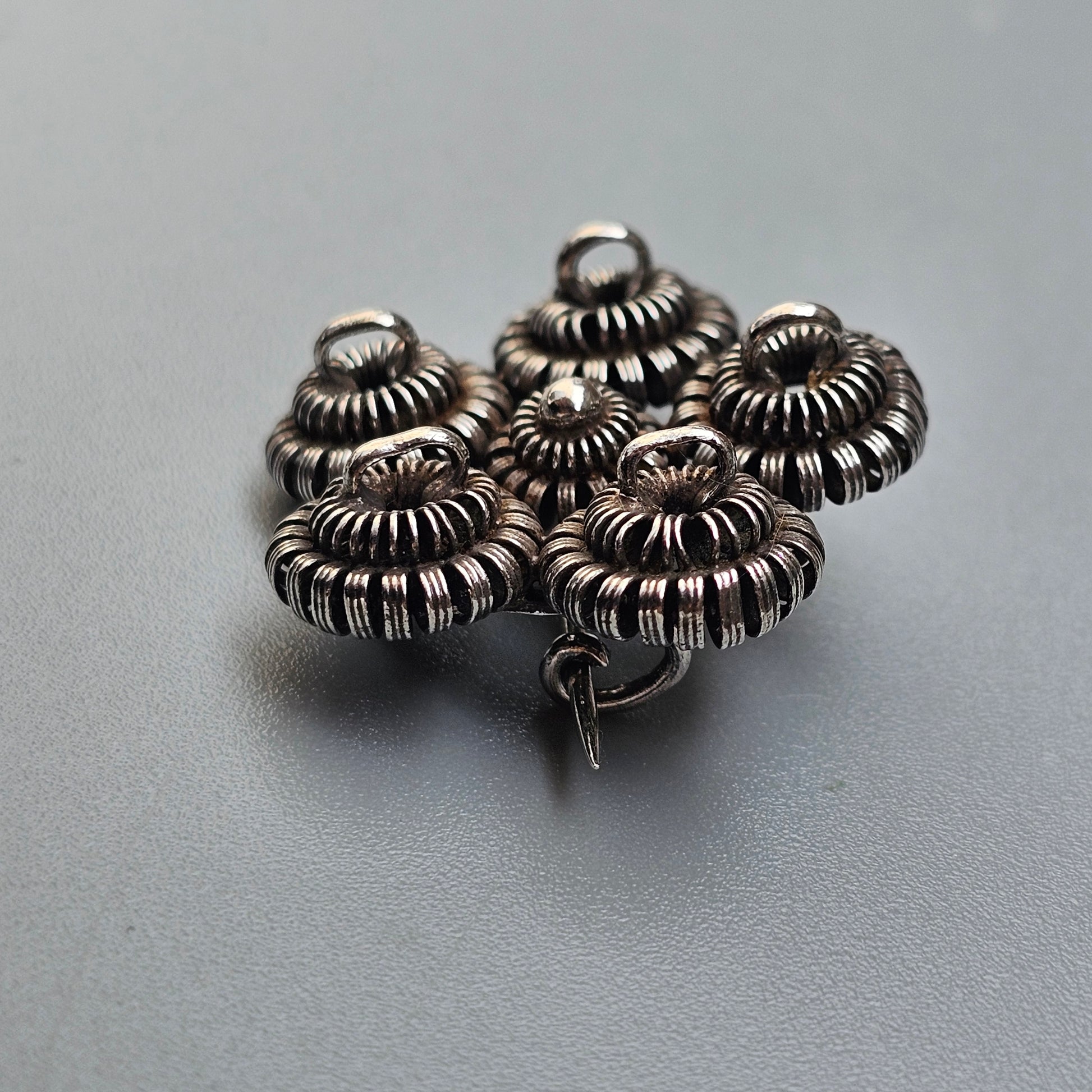 Intricate silver brooch with multiple coiled circular designs.