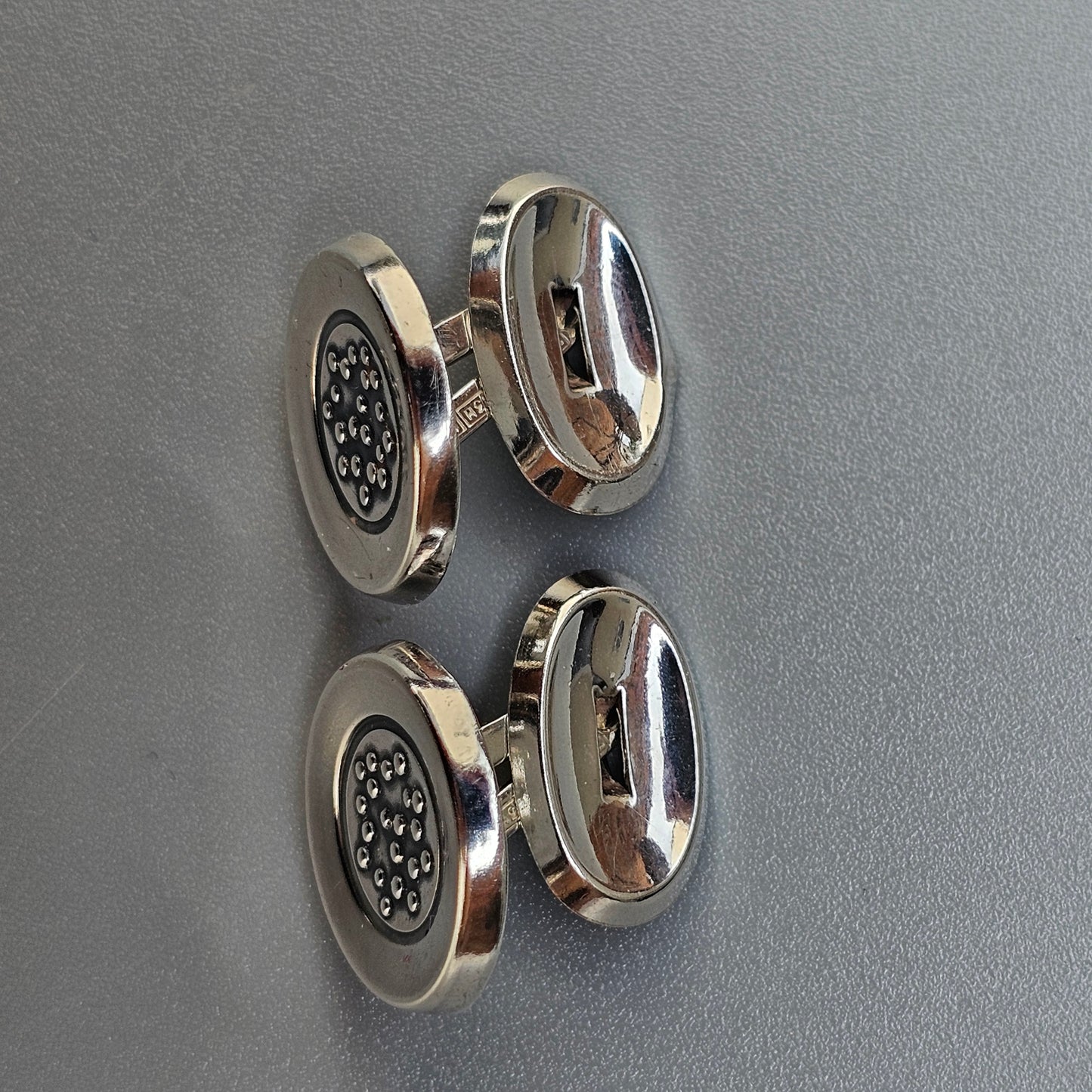 Pair of silver cufflinks with circular designs.