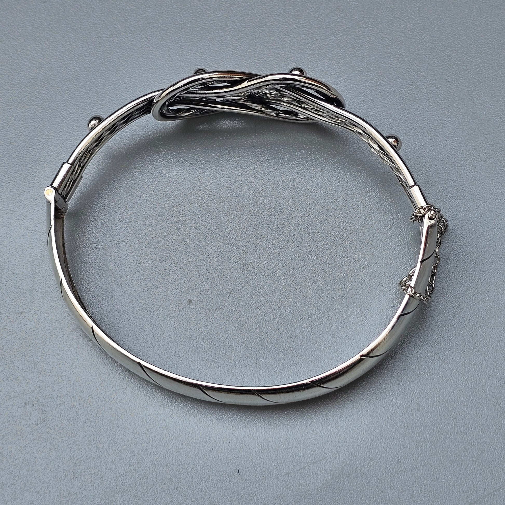 Silver bracelet with an intricate twisted wire design.