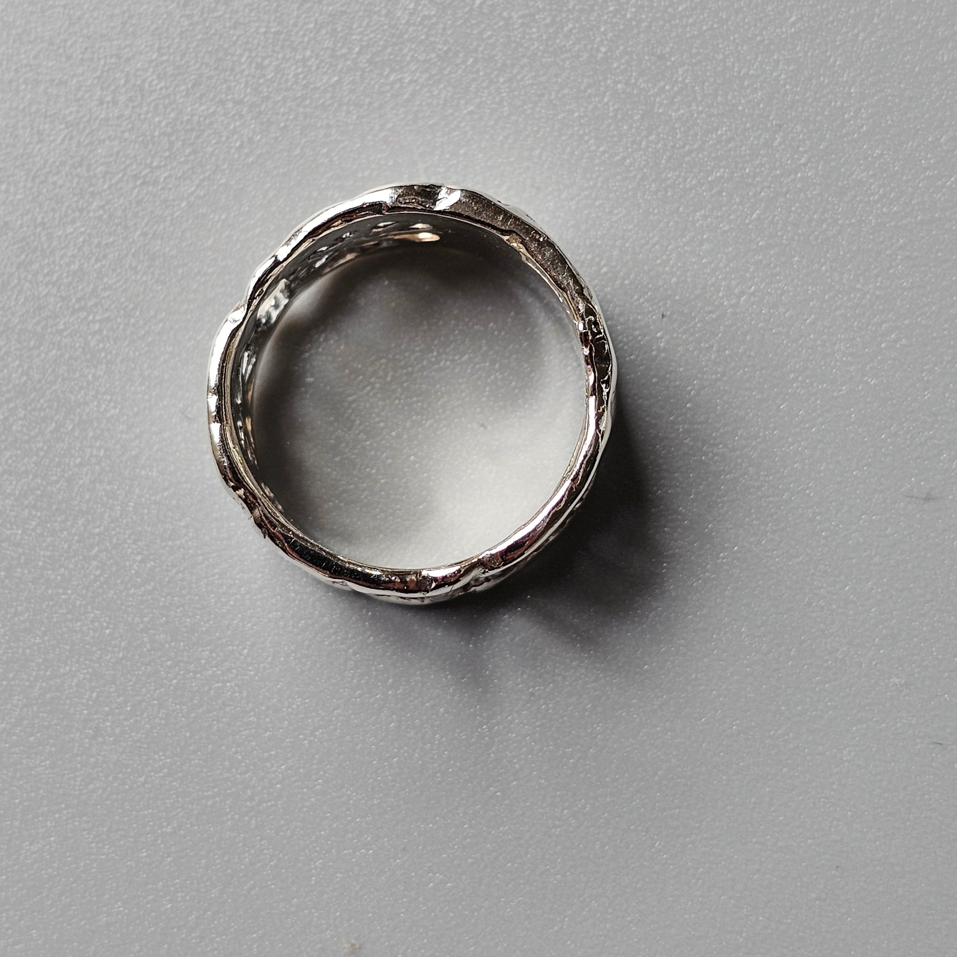 Silver ring with a textured, hammered surface.