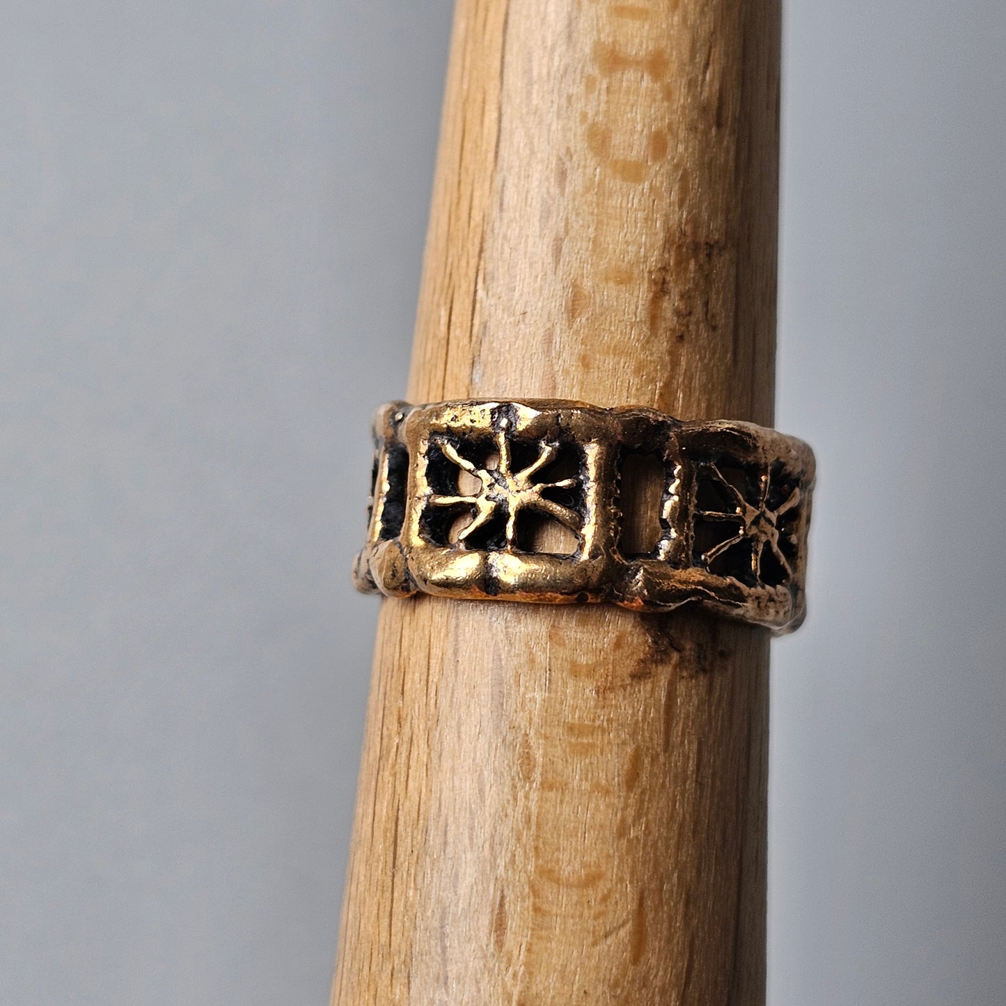 Ornate metal ring with star-like designs encircling its band.